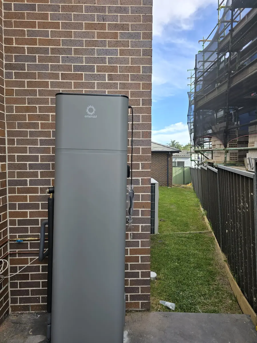 Emerald heat pump hot water system installed beside a brick home